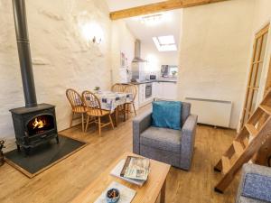 a living room with a wood stove and a table at Y Bwthyn in Dinorwic