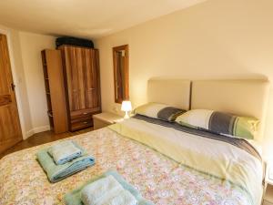 a bedroom with a bed with two towels on it at Y Bwthyn in Dinorwic