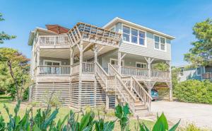 a large house with wooden stairs in front of it at A Summer Place in Duck
