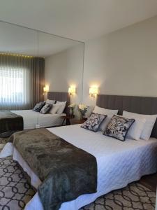ポルトにあるTrindade Apartmentsのベッド2台と鏡が備わるホテルルームです。