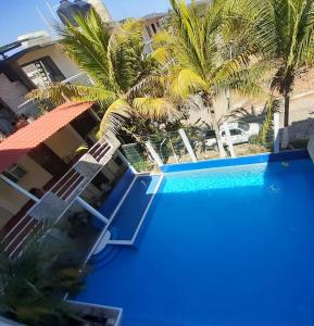 a view of a blue swimming pool with palm trees at Hotel Doña Mary Huatulco in Santa Cruz Huatulco