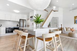 a kitchen and living room with a counter and stools at The Noosa Apartments in Noosa Heads