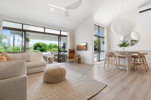 sala de estar con sofá y mesa en The Noosa Apartments, en Noosa Heads