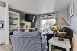 a living room with a couch and a table with a lamp at Coastal Waters in New Smyrna Beach