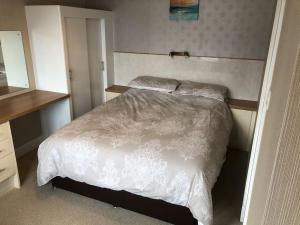 a bedroom with a bed with white sheets and pillows at Marine House Holiday Home in Portree