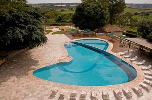 einen Blick über einen Pool mit Stühlen in der Unterkunft Hotel Michelangelo in Sao Jose do Rio Preto