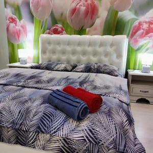 a bed with two pillows on it with pink flowers at уютные апартаменты на Брестской 171 in Pinsk