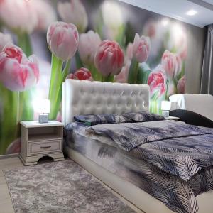 a bedroom with pink tulips on the wall at уютные апартаменты на Брестской 171 in Pinsk