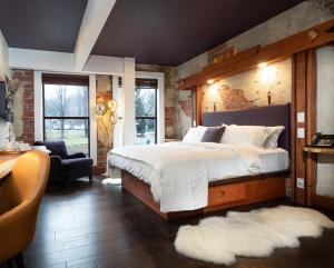 ein Schlafzimmer mit einem großen weißen Bett und einem Stuhl in der Unterkunft The Horton Hotel in Boone