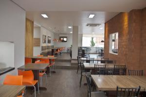 Un comedor con mesas y sillas en un restaurante. en Vallér Montanha Hotel Express, en Lajeado