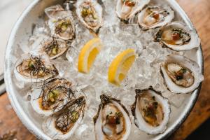 a plate of oysters on ice with lemon slices at B&B Tholen in Tholen