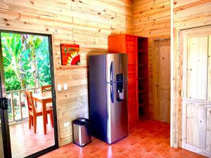 a stainless steel refrigerator in a room with a table at Ocean Melody 3 in Uvita