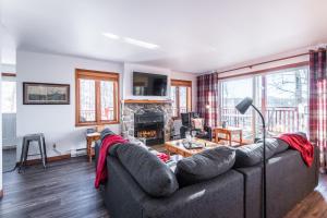 a living room with a couch and a fireplace at Hauts-bois Ski Inout 2brs Wpool Access 197-9 in Mont-Tremblant