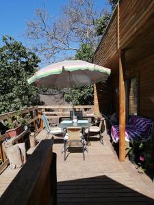 un patio con mesa, sillas y sombrilla en Casa en El Molle Valle del Elqui, en Vicuña