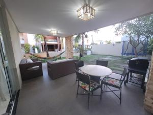 un patio con mesa, sillas y un columpio en Fantástica casa 4 quartos próxima a praia em condomínio fechado !, en Aracaju