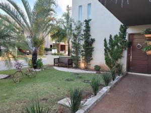 een huis met een tuin met een houten deur bij Fantástica casa 4 quartos próxima a praia em condomínio fechado ! in Aracaju