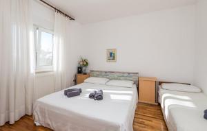 sypialnia z dwoma łóżkami i oknem w obiekcie House Noa w mieście Malinska