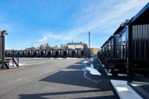 een rij treinwagons geparkeerd op een parkeerplaats bij HOTEL R9 The Yard Inabe in Kuwana