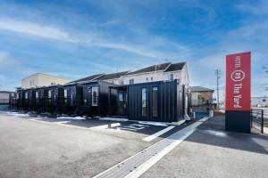 桑名市HOTEL R9 The Yard Inabe的停在停车场的一排黑货柜