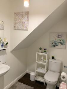 y baño con aseo blanco y lavamanos. en Spacious and amazing 4 bedroom detached house, en Mánchester