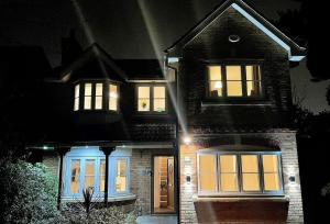 Una casa de noche con las luces encendidas en Spacious and amazing 4 bedroom detached house, en Mánchester