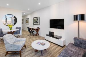 a living room filled with furniture and a tv at Meriton Suites Mascot Central in Sydney