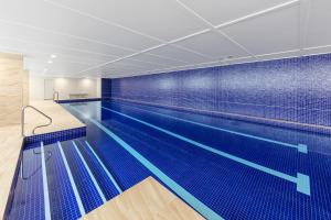 a blue and white swimming pool in a building at Meriton Suites Mascot Central in Sydney