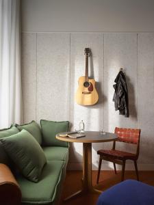 a living room with a couch and a table and a guitar at Ace Hotel Sydney in Sydney