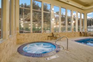 a swimming pool with a pool table and chairs in front of it at Holiday Inn Express & Suites Custer-Mt Rushmore in Custer