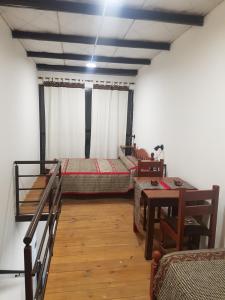 a room with two beds and a table in it at LOS LILOS - Otros Aires in Tilcara