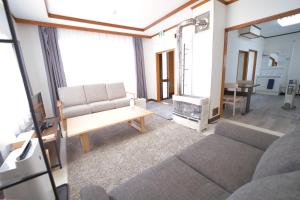 - un salon avec un canapé et une table dans l'établissement Furano Ski House, à Furano