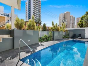 Una piscina en el patio trasero de un apartamento con edificios. en Eden Apartments Unit 401, en Gold Coast