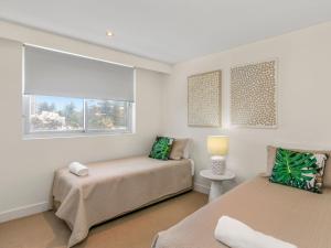 Un dormitorio con dos camas y una ventana. en Eden Apartments Unit 401, en Gold Coast 14 fotos más