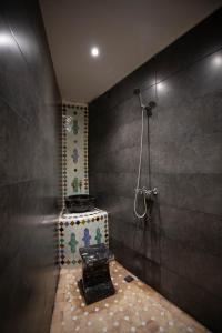 La salle de bains est pourvue d'une douche et d'un sol en pierre. dans l'établissement Riad Soultana, à Fès