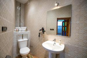 a bathroom with a toilet and a sink and a mirror at Riad Soultana in Fez