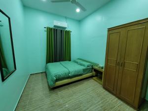 - une petite chambre avec un lit et une armoire dans l'établissement Nipah Homestay Kuala Besut, à Kampung Kuala Besut