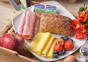 a plate of breakfast food with fruit and bread at Turquoise B&B in Willemstad