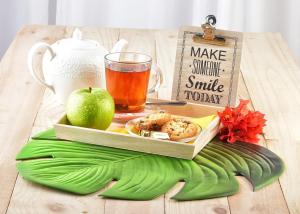 a tray with an apple and a plate of food on a table at Turquoise B&B in Willemstad
