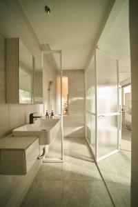 a bathroom with a sink and a glass shower at M Village The Garden in Ho Chi Minh City