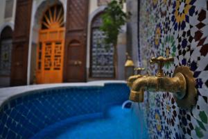 a faucet on a wall next to a building at Riad Soultana in Fez