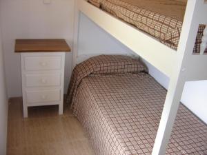 a small bedroom with a bed and a desk at Apartaments Fincasol in L'Estartit