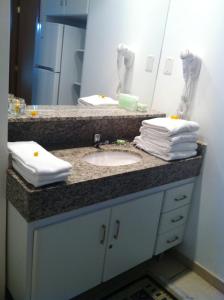 a bathroom counter with a sink and a mirror at Hot Park - 400 metros in Rio Quente