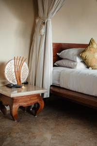 a bedroom with a bed and a table with chairs at Mandala Desa in Sukawati