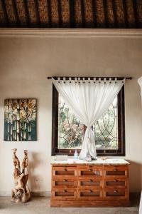 a bedroom with a dresser and a window at Mandala Desa in Sukawati