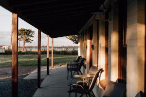une terrasse couverte avec des chaises et des tables sur une maison dans l'établissement Port Albert Motel, à Port Albert