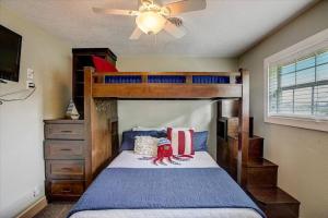 a bedroom with a bunk bed and a ceiling fan at Sandy Feet Retreat on LBJ - Pool, Hot Tub, Kayaks in Kingsland +13 photos