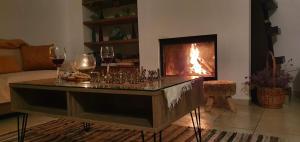 a living room with a fireplace and glasses of wine at The Mountain House in Ktima +24 photos
