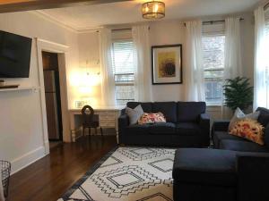 sala de estar con sofá y alfombra en J Birds’ Bungalow in the heart of Midtown, en Memphis