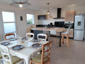 - une cuisine et une salle à manger avec une table et des chaises dans l'établissement Single-storey holiday home in Cleder, à Cléder