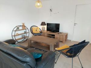 - un salon avec un canapé en cuir et une table dans l'établissement Single-storey holiday home in Cleder, à Cléder